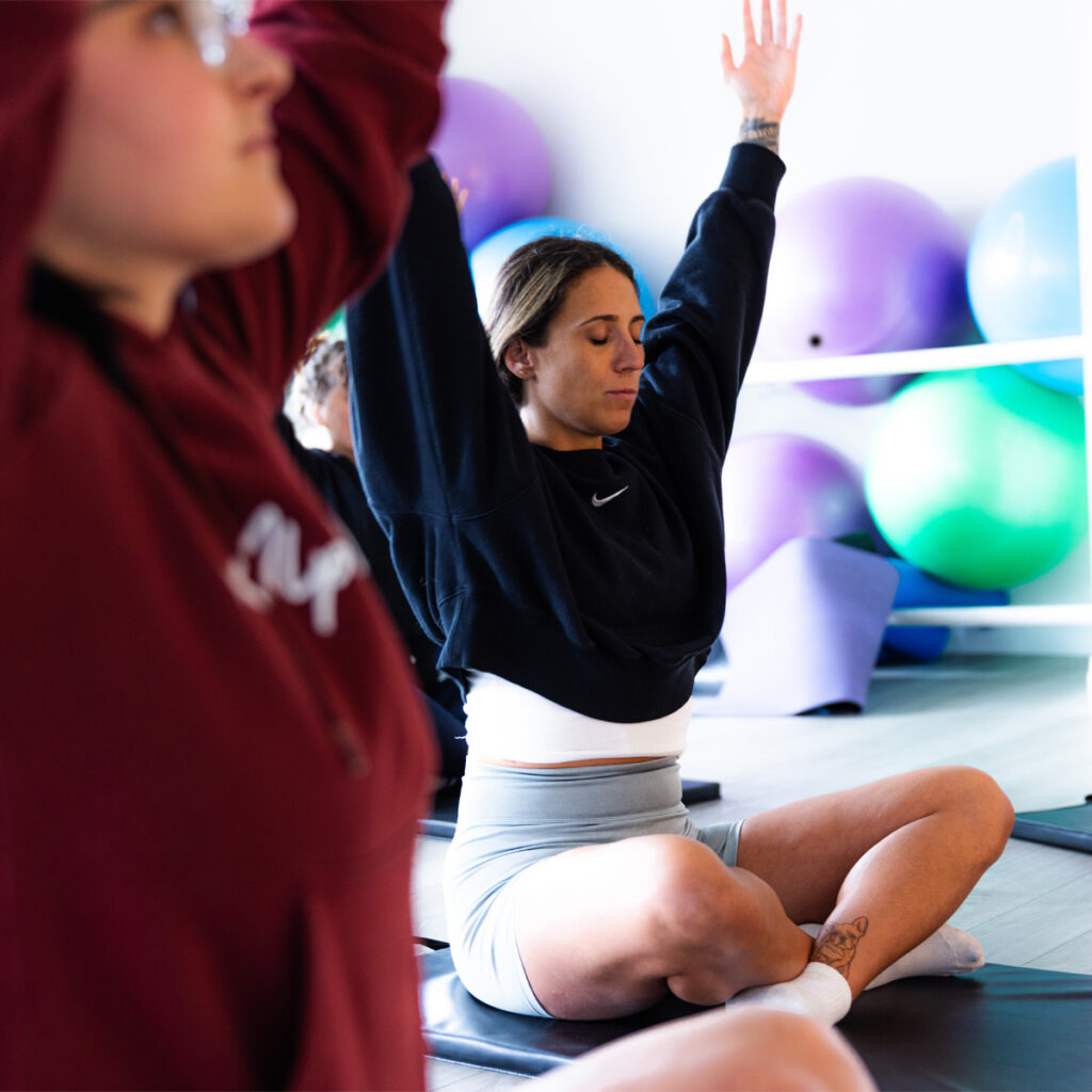 People stretching in a somatic and yoga class